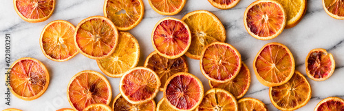 Fotografia A narrow view of spiced and roasted orange slices spread on a marble slab