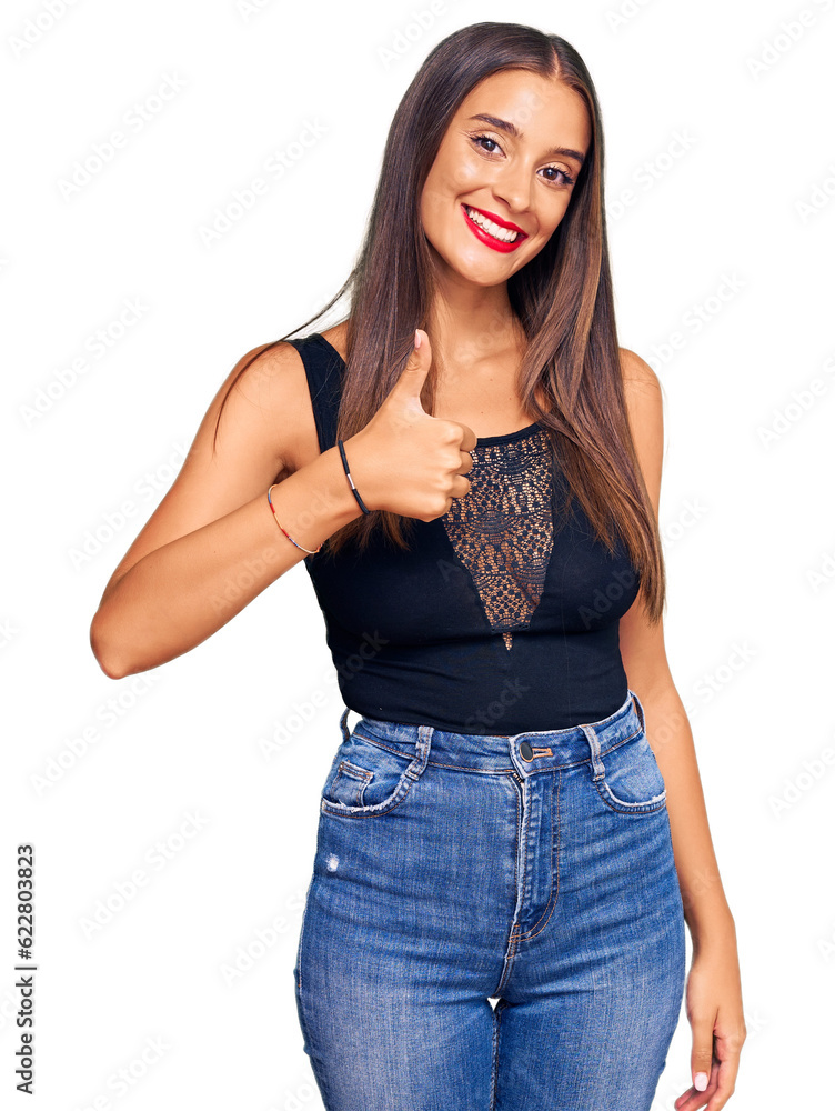 Young hispanic woman wearing casual clothes doing happy thumbs up gesture with hand. approving expression looking at the camera showing success. Young hispanic woman wearing casual clothes doing happy thumbs up gesture with hand. approving expression looking at the camera showing success.
