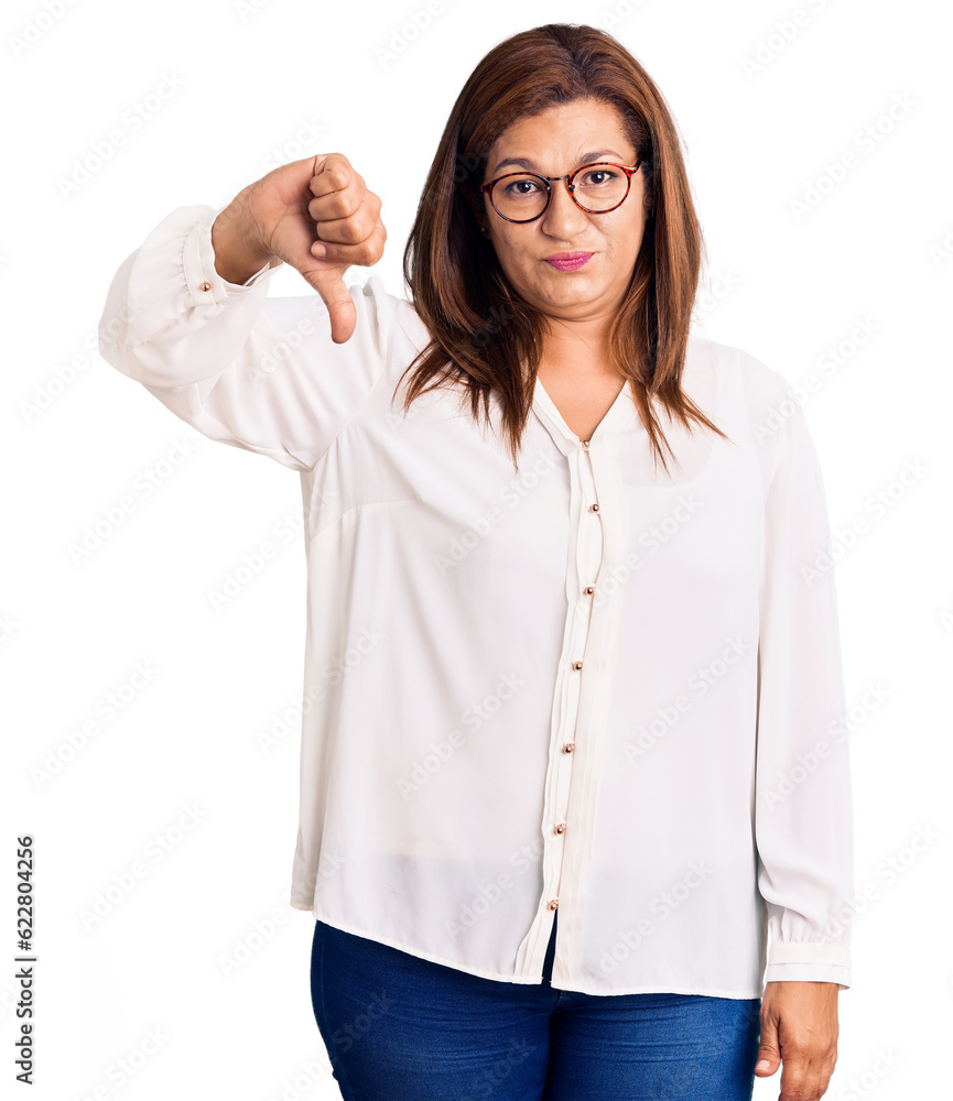 Middle age latin woman wearing casual clothes and glasses looking unhappy and angry showing rejection and negative with thumbs down gesture. bad expression. Middle age latin woman wearing casual clothes and glasses looking unhappy and angry showing rejection and negative with thumbs down gesture. bad expression.