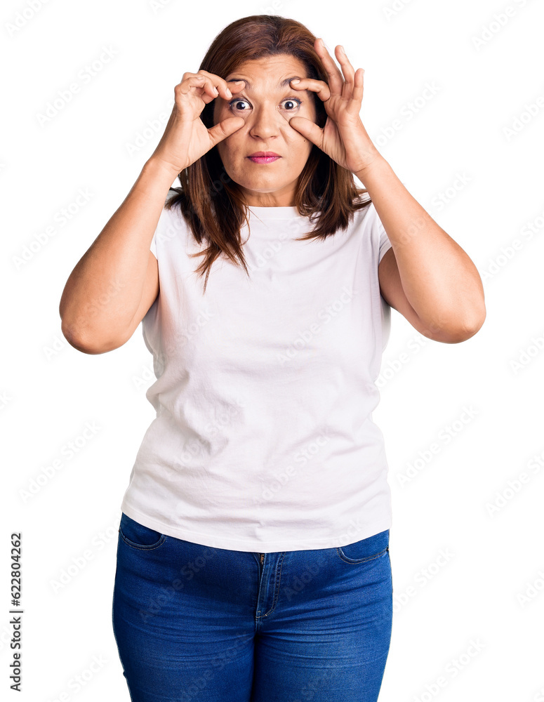 Middle age latin woman wearing casual white tshirt trying to open eyes with fingers, sleepy and tired for morning fatigue Middle age latin woman wearing casual white tshirt trying to open eyes with fingers, sleepy and tired for morning fatigue