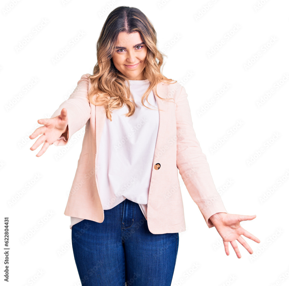 Young caucasian woman wearing business clothes looking at the camera smiling with open arms for hug. cheerful expression embracing happiness. Young caucasian woman wearing business clothes looking at the camera smiling with open arms for hug. cheerful expression embracing happiness.