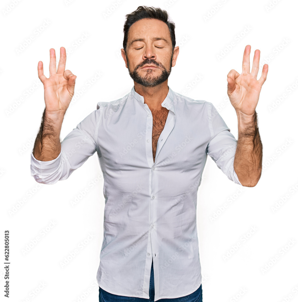Middle age man wearing casual clothes relax and smiling with eyes closed doing meditation gesture with fingers. yoga concept. Middle age man wearing casual clothes relax and smiling with eyes closed doing meditation gesture with fingers. yoga concept.