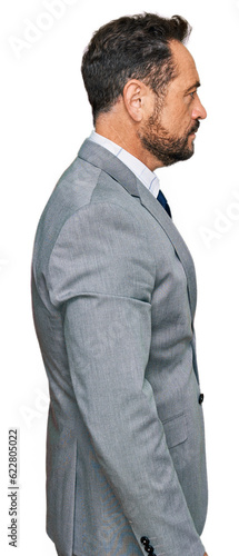 Middle age man wearing business clothes looking to side, relax profile pose with natural face and confident smile.