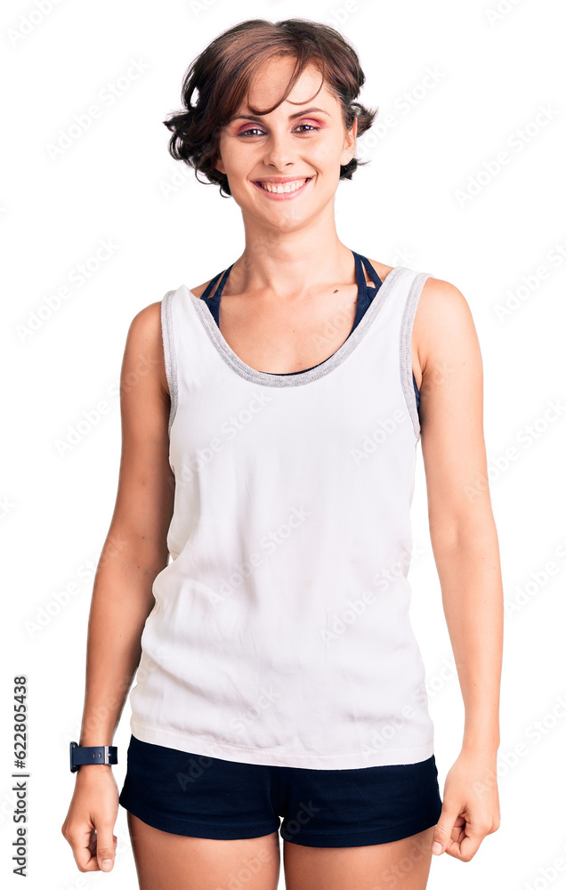 Beautiful young woman with short hair wearing casual sport clothes looking positive and happy standing and smiling with a confident smile showing teeth Beautiful young woman with short hair wearing casual sport clothes looking positive and happy standing and smiling with a confident smile showing teeth
