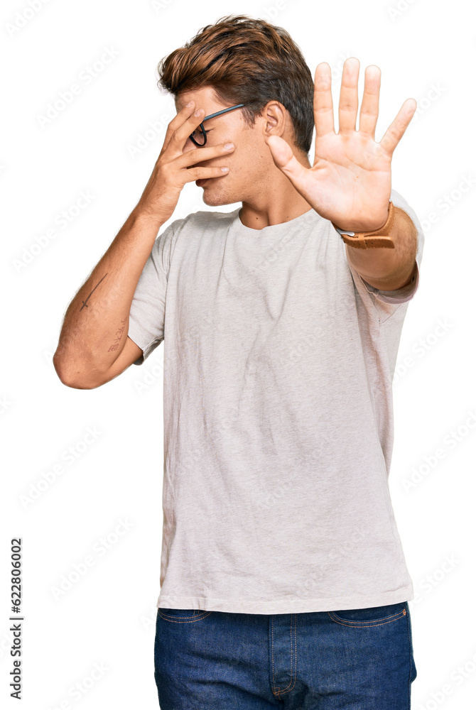 Fototapeta premium Handsome caucasian man wearing casual clothes and glasses covering eyes with hands and doing stop gesture with sad and fear expression. embarrassed and negative concept.