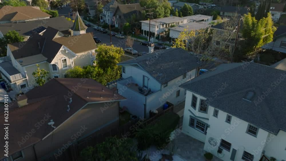 High angle view of residential houses along streets in city. Tilt up reveal of skyline with downtown skyscrapers. Los Angeles, California, USA High angle view of residential houses along streets in city. Tilt up reveal of skyline with downtown skyscrapers. Los Angeles, California, USA
