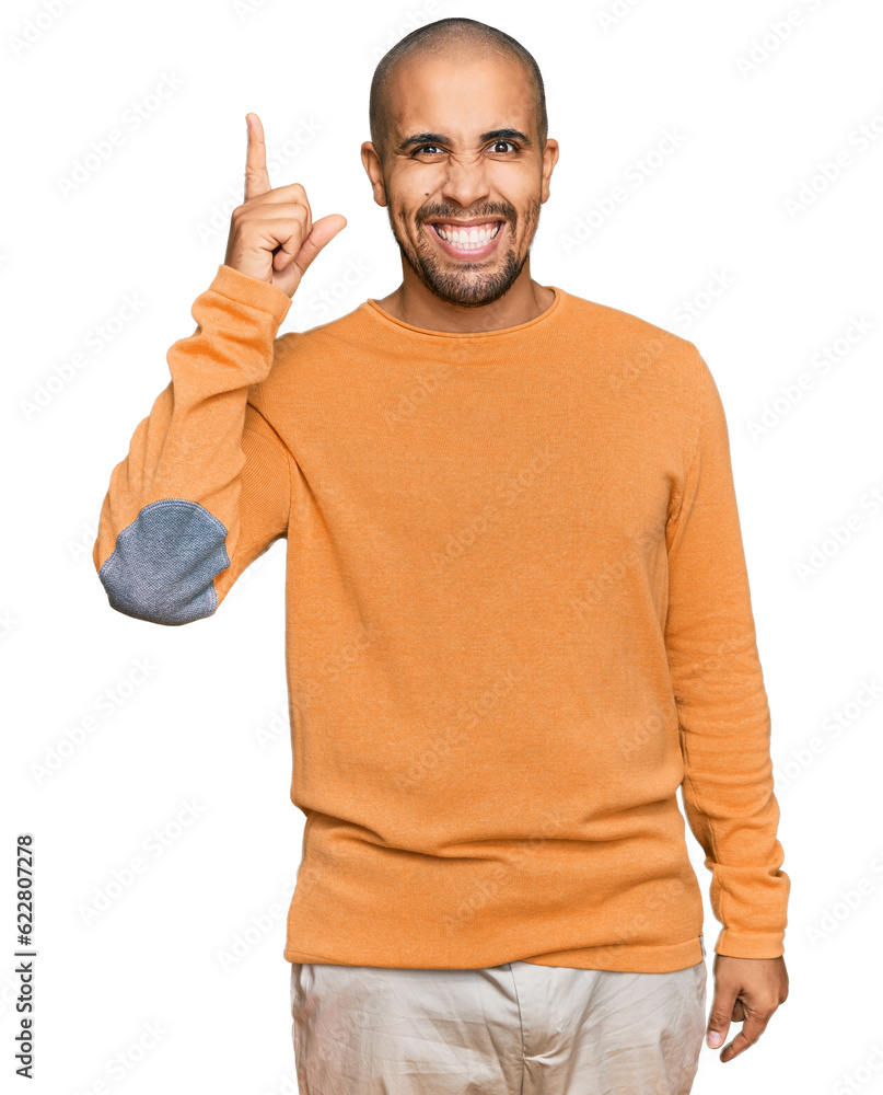 Naklejka premium Hispanic adult man wearing casual winter sweater pointing finger up with successful idea. exited and happy. number one.