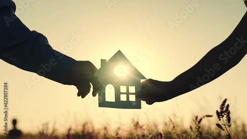 construction  residential building. sign symbol house  woman man holding paper house sunset. happy family lifestyle. silhouette sunlight window. credit epoteka loan purchase housing. ecology sunset photo