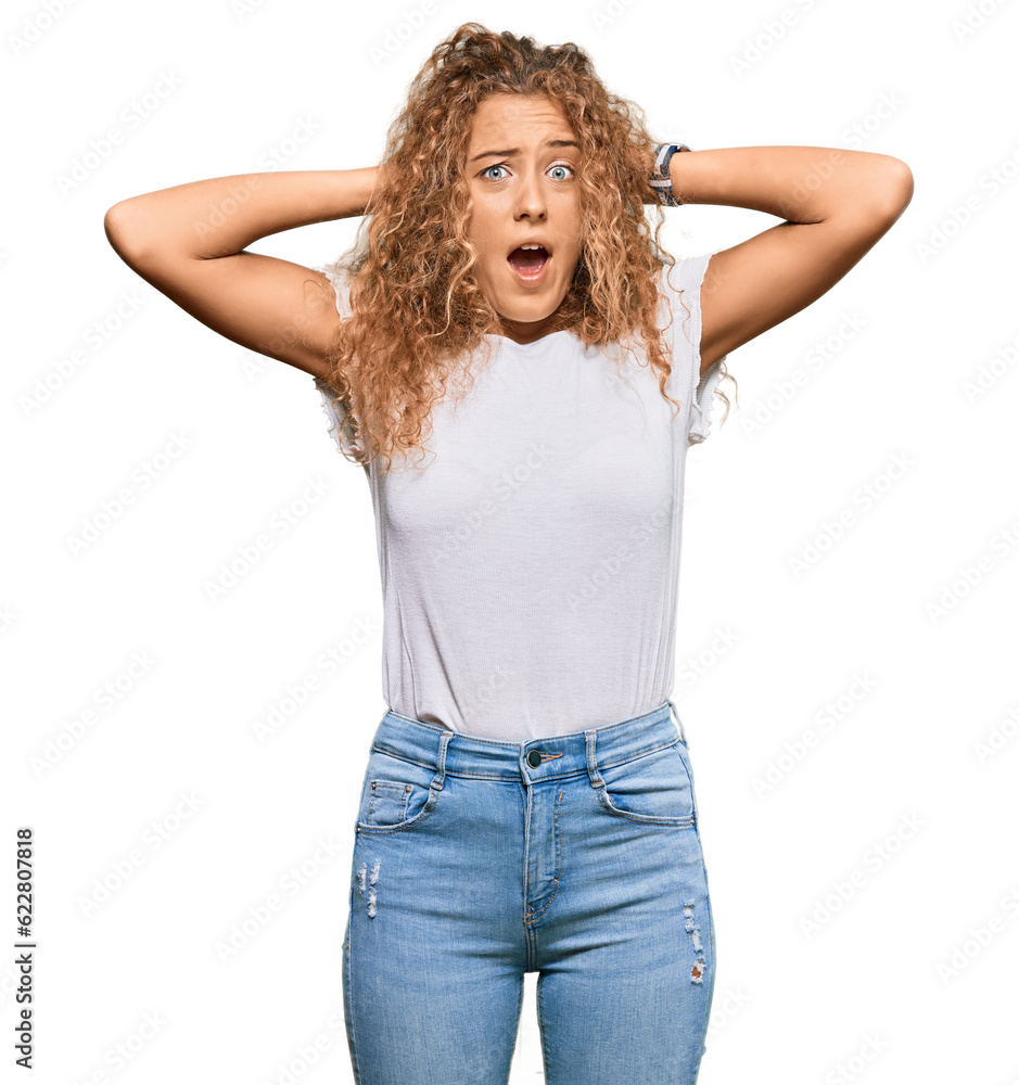 Beautiful caucasian teenager girl wearing casual white tshirt crazy and scared with hands on head, afraid and surprised of shock with open mouth Beautiful caucasian teenager girl wearing casual white tshirt crazy and scared with hands on head, afraid and surprised of shock with open mouth