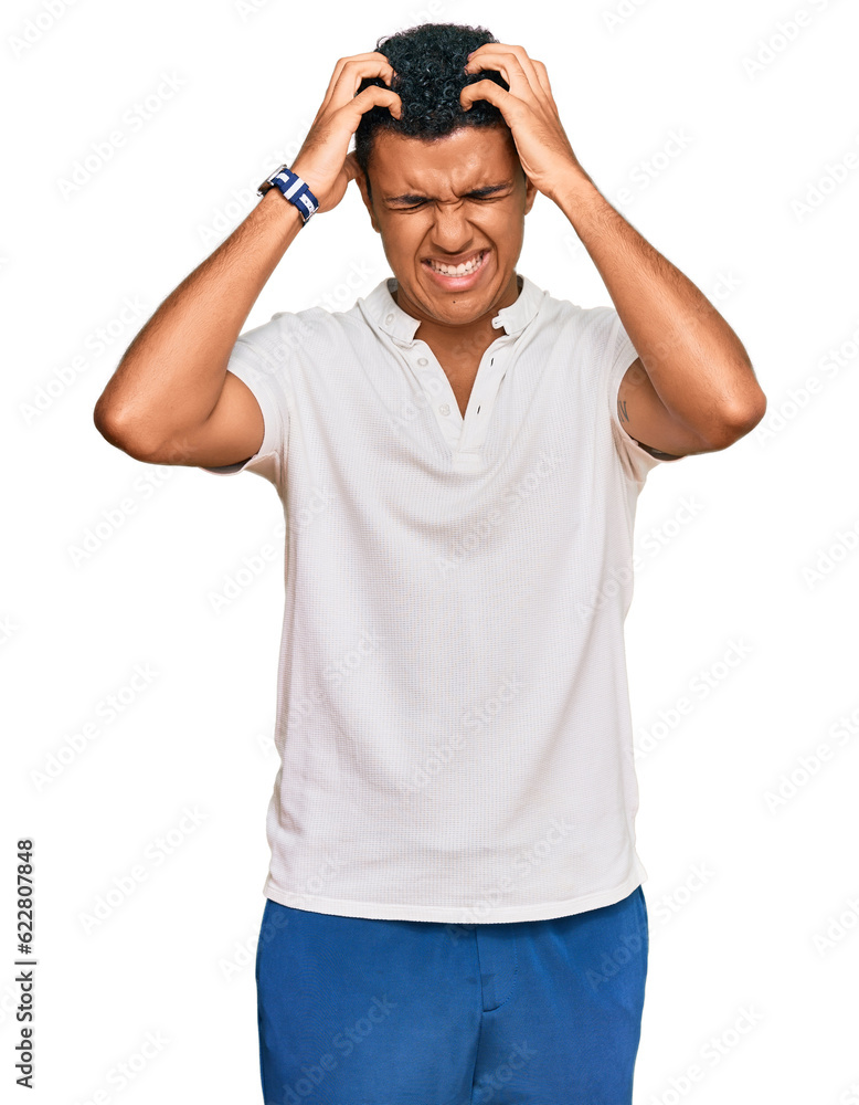 Young arab man wearing casual clothes suffering from headache desperate and stressed because pain and migraine. hands on head. Young arab man wearing casual clothes suffering from headache desperate and stressed because pain and migraine. hands on head.
