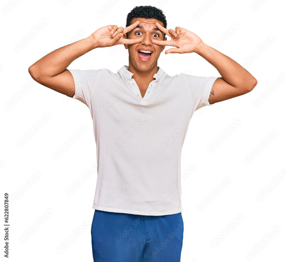 Young arab man wearing casual clothes doing peace symbol with fingers over face, smiling cheerful showing victory Young arab man wearing casual clothes doing peace symbol with fingers over face, smiling cheerful showing victory