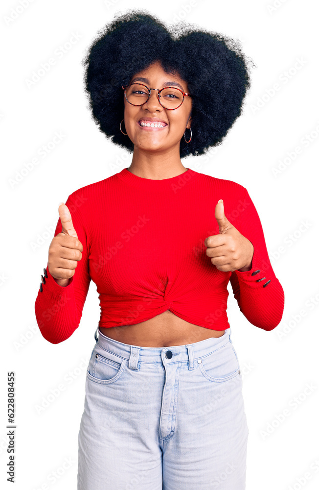Young african american girl wearing casual clothes and glasses success sign doing positive gesture with hand, thumbs up smiling and happy. cheerful expression and winner gesture. Young african american girl wearing casual clothes and glasses success sign doing positive gesture with hand, thumbs up smiling and happy. cheerful expression and winner gesture.