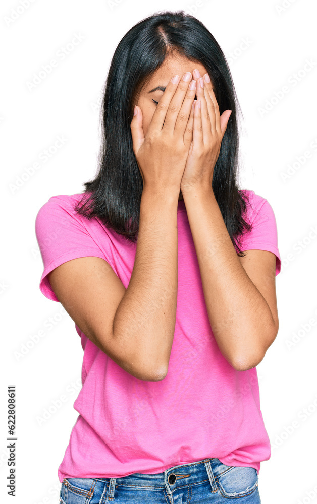 Beautiful asian young woman wearing casual pink t shirt with sad expression covering face with hands while crying. depression concept. Beautiful asian young woman wearing casual pink t shirt with sad expression covering face with hands while crying. depression concept.