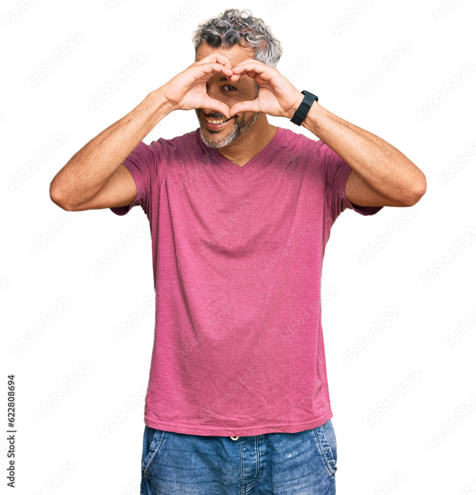 Middle age grey-haired man wearing casual clothes doing heart shape with hand and fingers smiling looking through sign Middle age grey-haired man wearing casual clothes doing heart shape with hand and fingers smiling looking through sign