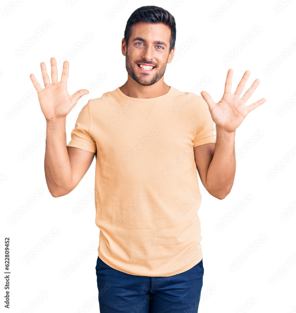 Naklejka premium Young hispanic man wearing casual clothes showing and pointing up with fingers number ten while smiling confident and happy.