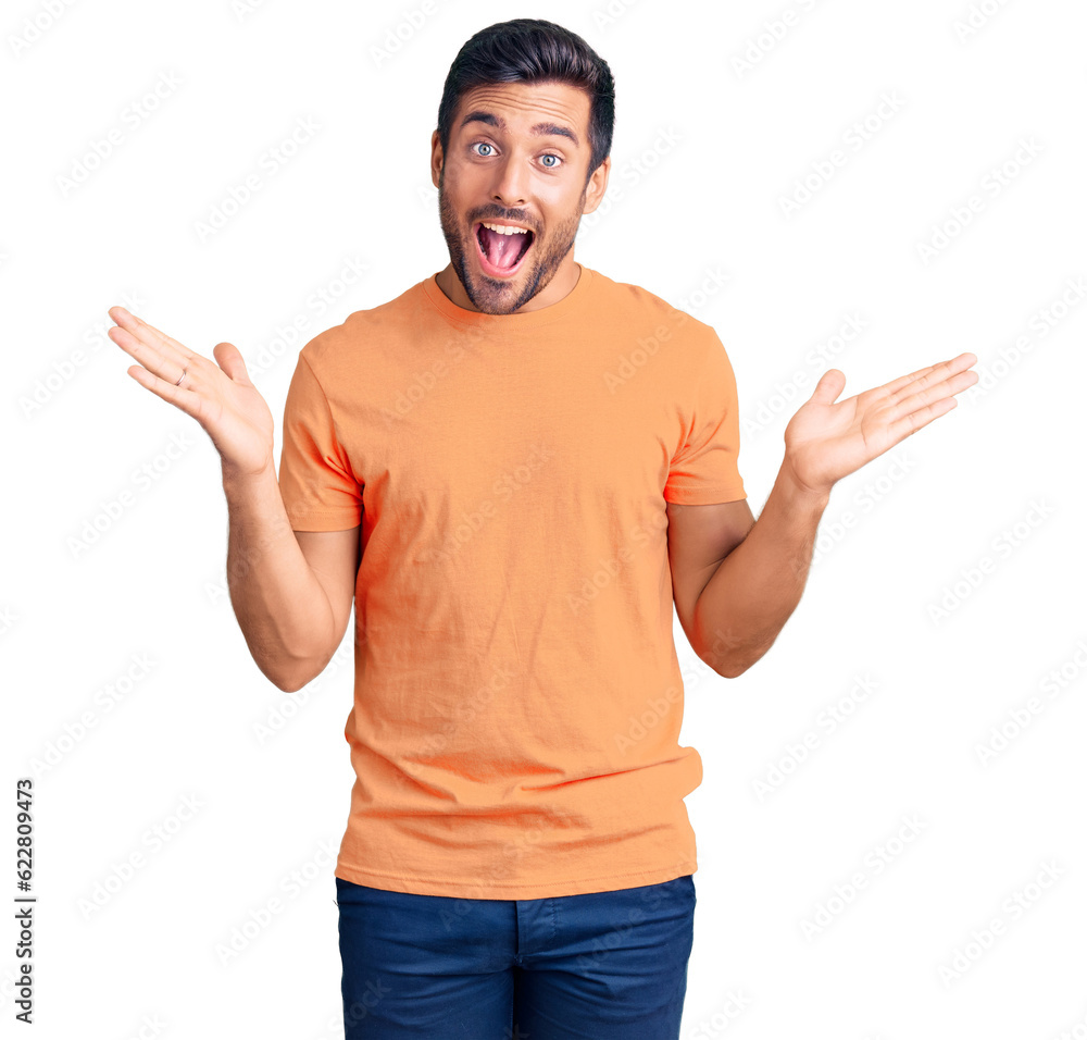 Fototapeta premium Young hispanic man wearing casual clothes celebrating victory with happy smile and winner expression with raised hands