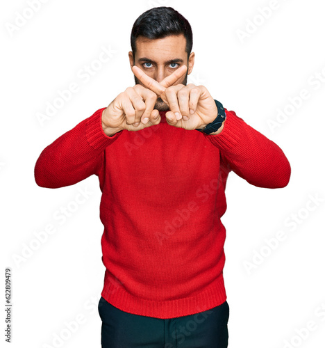 Young hispanic man wearing casual clothes rejection expression crossing fingers doing negative sign