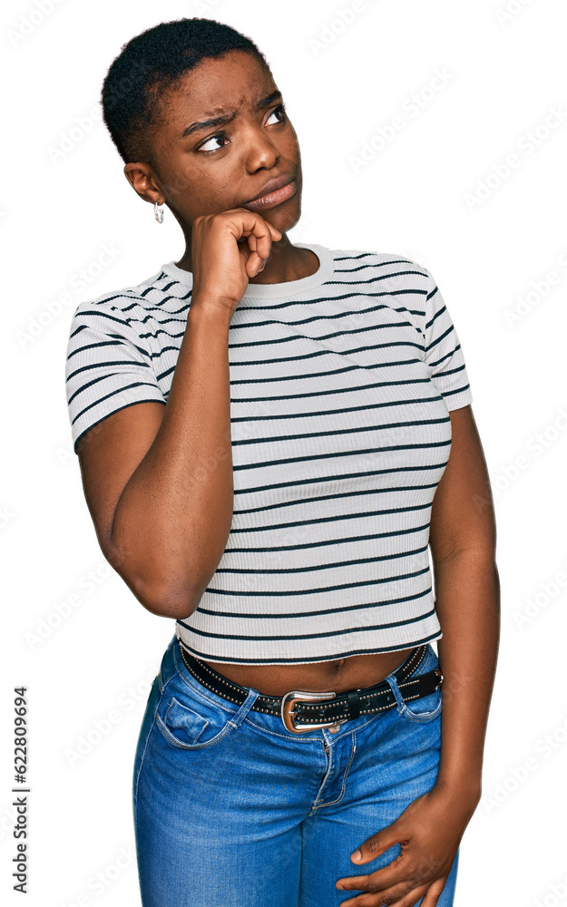 Young african american woman wearing casual clothes serious face thinking about question with hand on chin, thoughtful about confusing idea Young african american woman wearing casual clothes serious face thinking about question with hand on chin, thoughtful about confusing idea