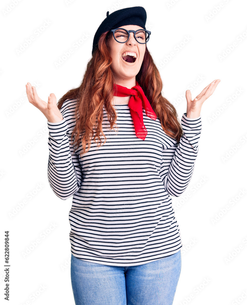 Young beautiful woman wearing french look with beret crazy and mad shouting and yelling with aggressive expression and arms raised. frustration concept.