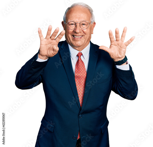 Senior man with grey hair wearing business suit and glasses showing and pointing up with fingers number nine while smiling confident and happy.