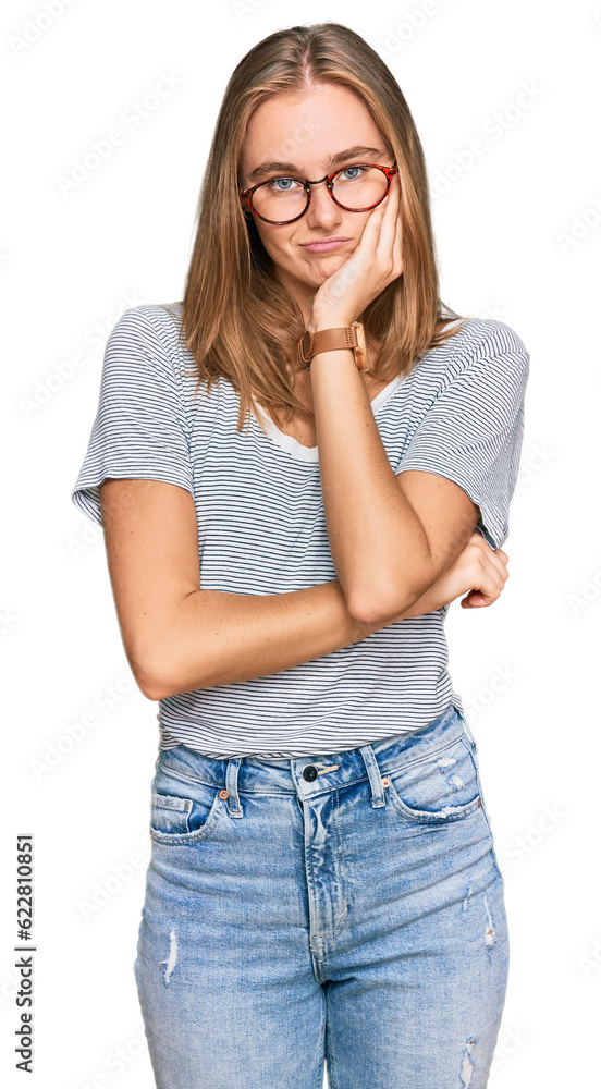 Beautiful young blonde woman wearing casual clothes and glasses thinking looking tired and bored with depression problems with crossed arms. Beautiful young blonde woman wearing casual clothes and glasses thinking looking tired and bored with depression problems with crossed arms.