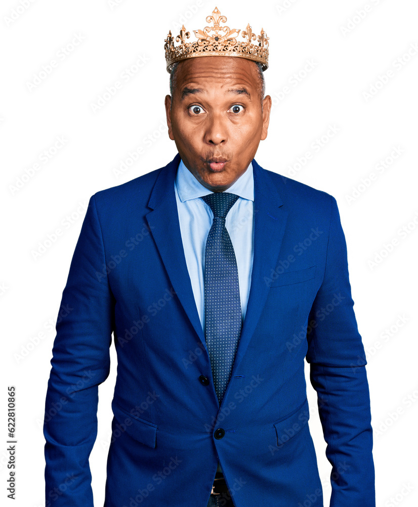 Hispanic middle age man wearing king crown scared and amazed with open mouth for surprise, disbelief face Hispanic middle age man wearing king crown scared and amazed with open mouth for surprise, disbelief face