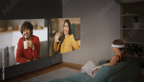 Woman In Headset Communicating With Friends Via Virtual Reality Indoors