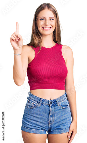 Young beautiful blonde woman wearing elegant summer shirt showing and pointing up with finger number one while smiling confident and happy.