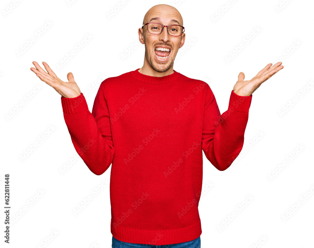 Bald man with beard wearing casual clothes and glasses celebrating victory with happy smile and winner expression with raised hands Bald man with beard wearing casual clothes and glasses celebrating victory with happy smile and winner expression with raised hands