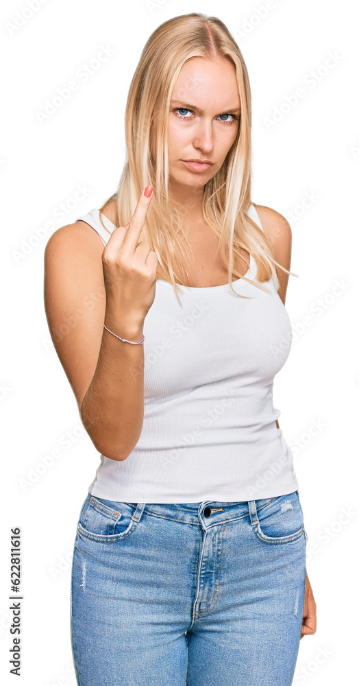 Young blonde girl wearing casual style with sleeveless shirt showing middle finger, impolite and rude fuck off expression Young blonde girl wearing casual style with sleeveless shirt showing middle finger, impolite and rude fuck off expression