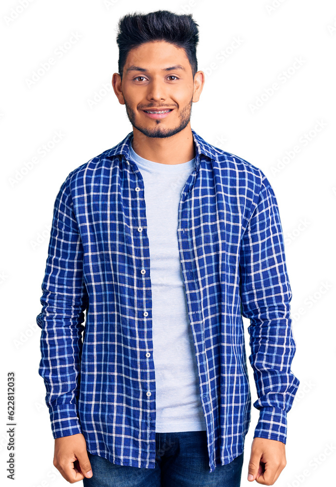 Handsome latin american young man wearing casual shirt looking positive and happy standing and smiling with a confident smile showing teeth Handsome latin american young man wearing casual shirt looking positive and happy standing and smiling with a confident smile showing teeth