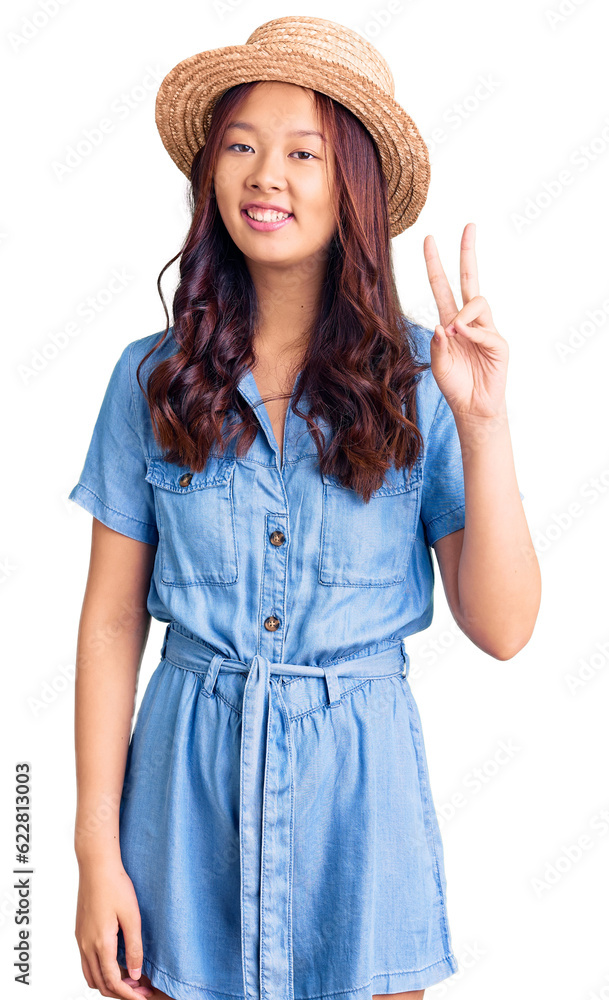 Young beautiful chinese girl wearing summer hat showing and pointing up with fingers number two while smiling confident and happy. Young beautiful chinese girl wearing summer hat showing and pointing up with fingers number two while smiling confident and happy.