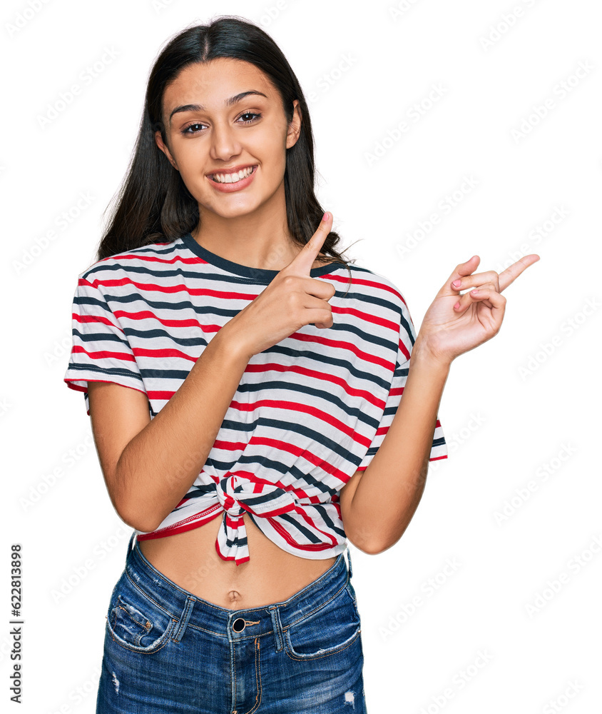 Young hispanic girl wearing casual clothes smiling and looking at the camera pointing with two hands and fingers to the side. Young hispanic girl wearing casual clothes smiling and looking at the camera pointing with two hands and fingers to the side.