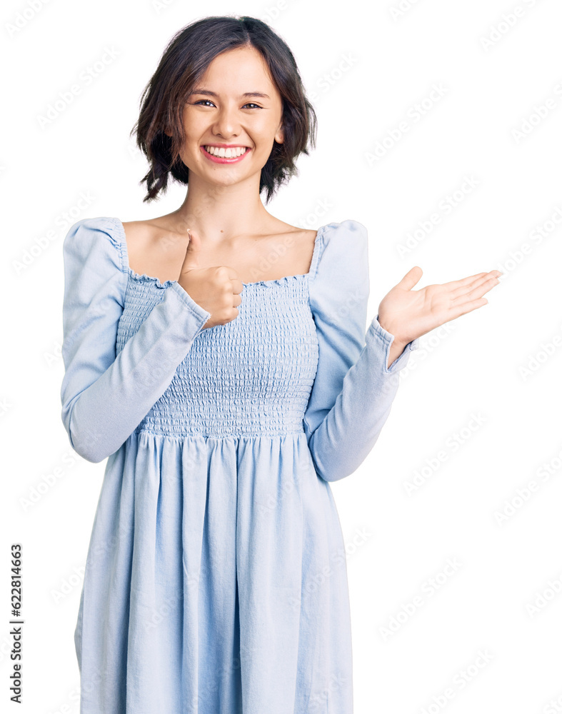 Young beautiful girl wearing casual clothes showing palm hand and doing ok gesture with thumbs up, smiling happy and cheerful Young beautiful girl wearing casual clothes showing palm hand and doing ok gesture with thumbs up, smiling happy and cheerful