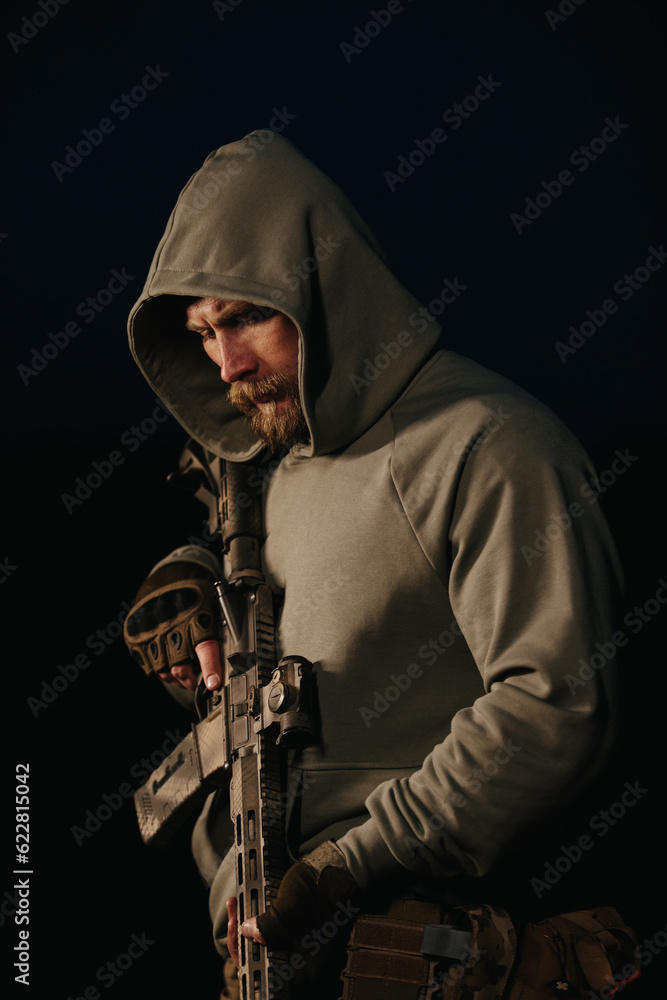 Naklejka premium Ukrainian defender with his weapon on a black background