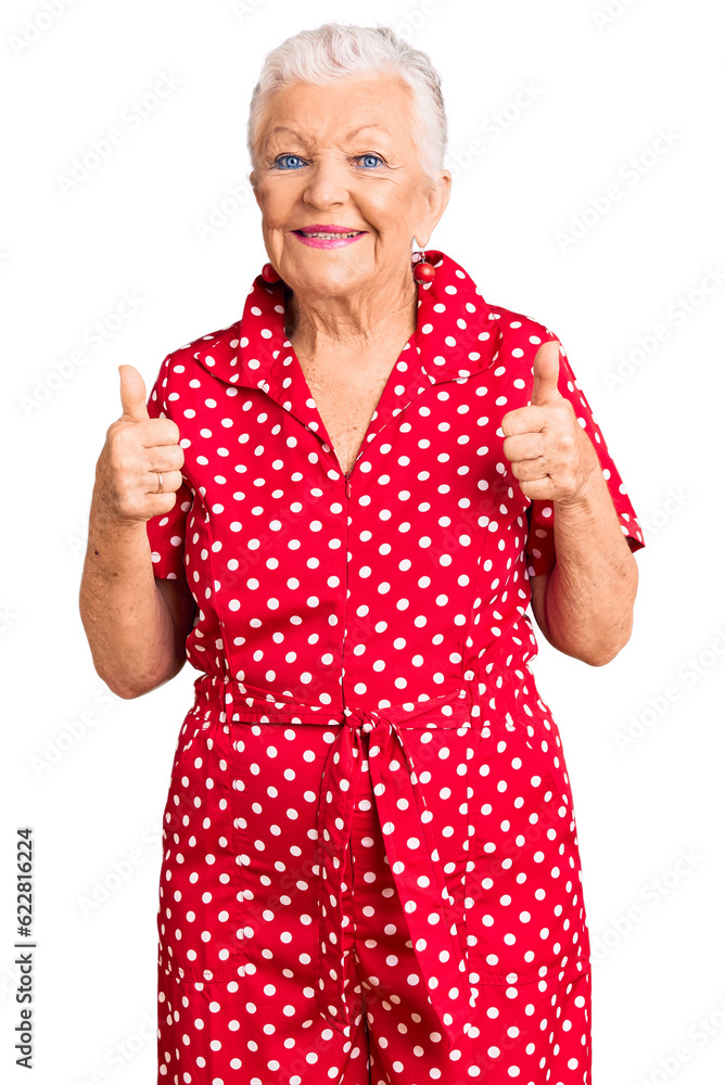 Senior beautiful woman with blue eyes and grey hair wearing a red summer dress success sign doing positive gesture with hand, thumbs up smiling and happy. cheerful expression and winner gesture. Senior beautiful woman with blue eyes and grey hair wearing a red summer dress success sign doing positive gesture with hand, thumbs up smiling and happy. cheerful expression and winner gesture.