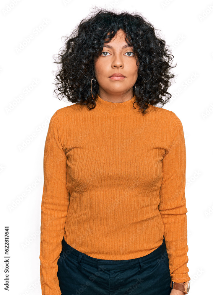 Young hispanic woman wearing casual clothes relaxed with serious expression on face. simple and natural looking at the camera. Young hispanic woman wearing casual clothes relaxed with serious expression on face. simple and natural looking at the camera.