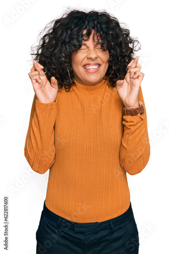 Young hispanic woman wearing casual clothes gesturing finger crossed smiling with hope and eyes closed. luck and superstitious concept.