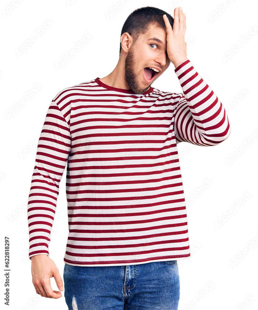 Young handsome man wearing striped sweater surprised with hand on head for mistake, remember error. forgot, bad memory concept. Young handsome man wearing striped sweater surprised with hand on head for mistake, remember error. forgot, bad memory concept.