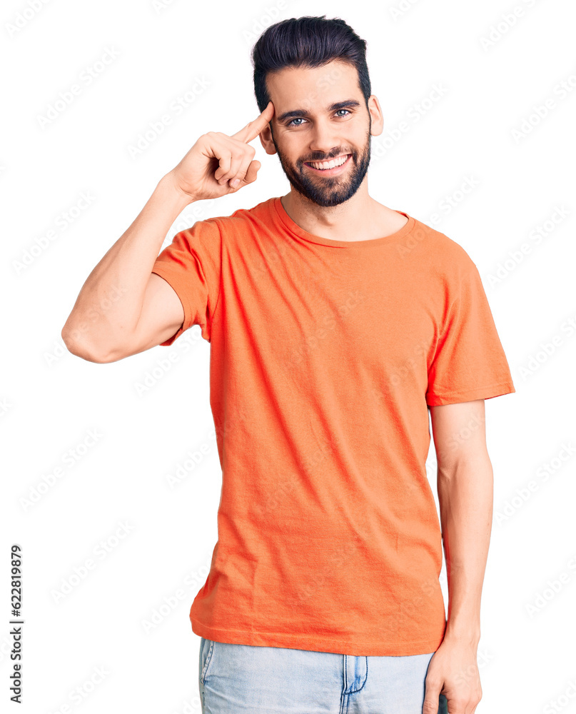 Young handsome man with beard wearing casual t-shirt smiling pointing to head with one finger, great idea or thought, good memory Young handsome man with beard wearing casual t-shirt smiling pointing to head with one finger, great idea or thought, good memory