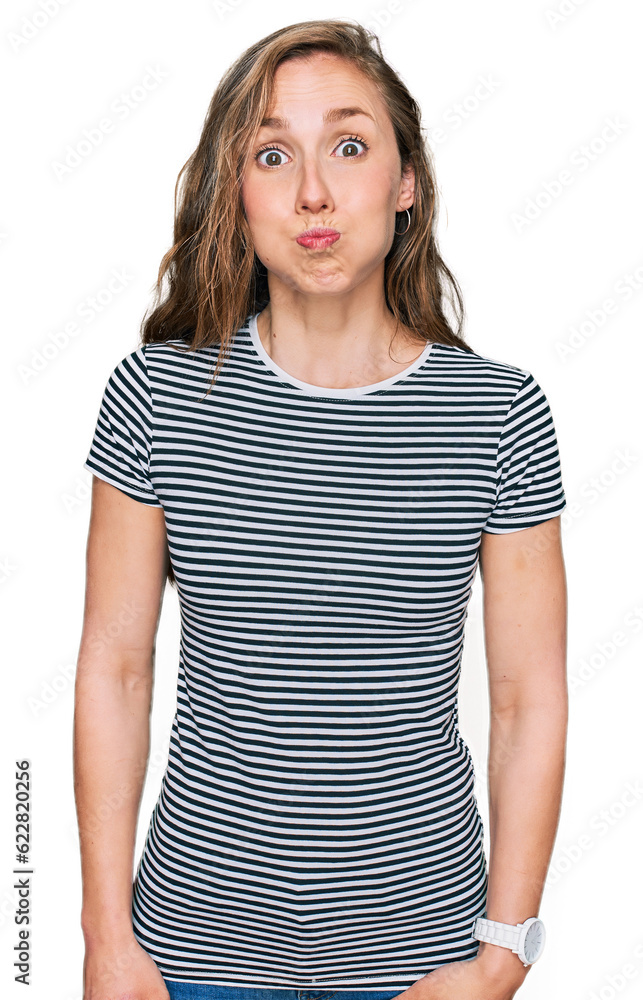Young blonde woman wearing casual clothes puffing cheeks with funny face. mouth inflated with air, crazy expression. Young blonde woman wearing casual clothes puffing cheeks with funny face. mouth inflated with air, crazy expression.