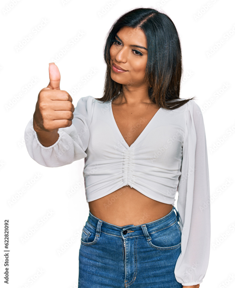 Young latin transsexual transgender woman wearing casual clothes looking proud, smiling doing thumbs up gesture to the side Young latin transsexual transgender woman wearing casual clothes looking proud, smiling doing thumbs up gesture to the side