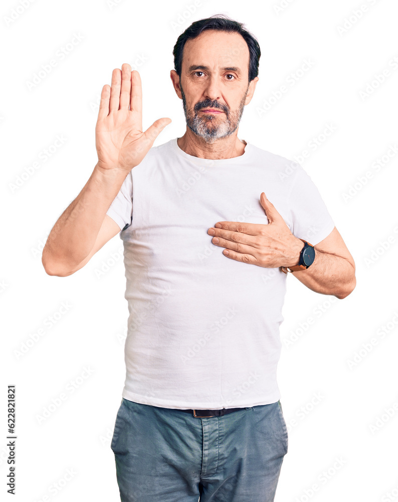 Middle age handsome man wearing casual t-shirt swearing with hand on chest and open palm, making a loyalty promise oath Middle age handsome man wearing casual t-shirt swearing with hand on chest and open palm, making a loyalty promise oath