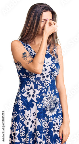 Beautiful caucasian woman wearing summer dress tired rubbing nose and eyes feeling fatigue and headache. stress and frustration concept. © Krakenimages.com