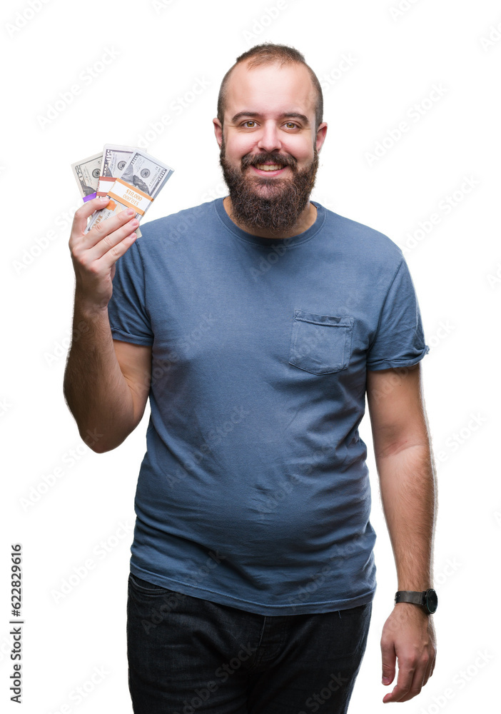 Young hipster man holding bunch of money over isolated background with a happy face standing and smiling with a confident smile showing teeth Young hipster man holding bunch of money over isolated background with a happy face standing and smiling with a confident smile showing teeth