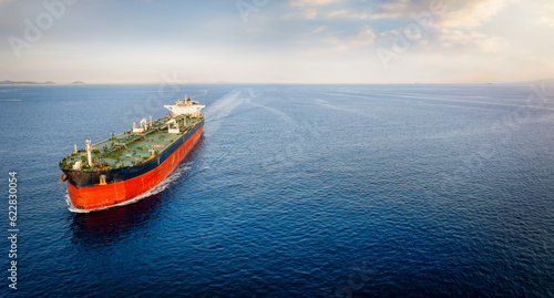 Aerial view of a large crude oil tanker traveling over calm sea during sunset with copy space photo