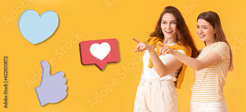 Young gossiping women and social network reactions on yellow background