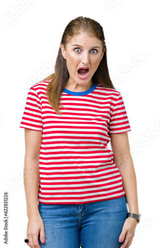 Middle age mature woman wearing casual t-shirt over isolated background In shock face, looking skeptical and sarcastic, surprised with open mouth
