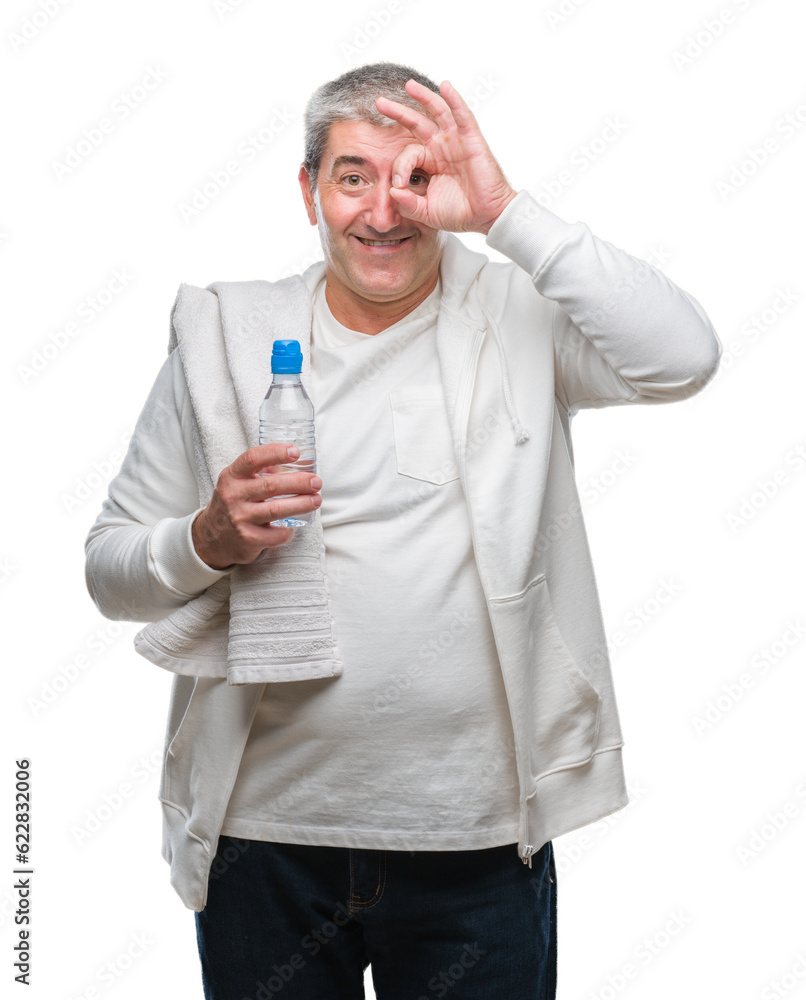 Handsome senior man training holding towel and water bottle over isolated background with happy face smiling doing ok sign with hand on eye looking through fingers Handsome senior man training holding towel and water bottle over isolated background with happy face smiling doing ok sign with hand on eye looking through fingers