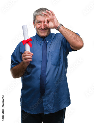 Handsome senior man holding degree over isolated background with happy face smiling doing ok sign with hand on eye looking through fingers